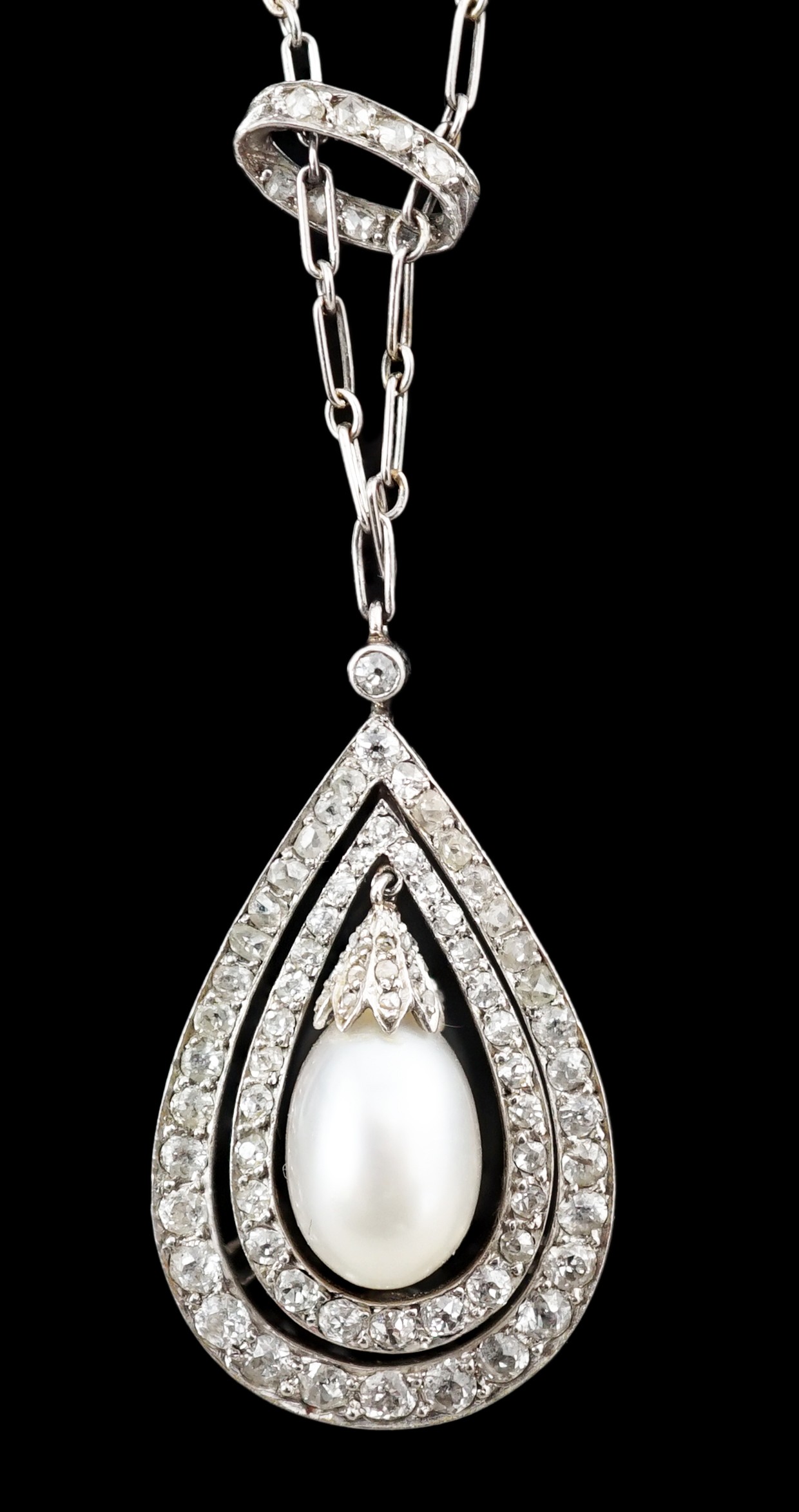 An early 20th century platinum, cultured? pearl and diamond cluster set pear shaped drop pendant necklace